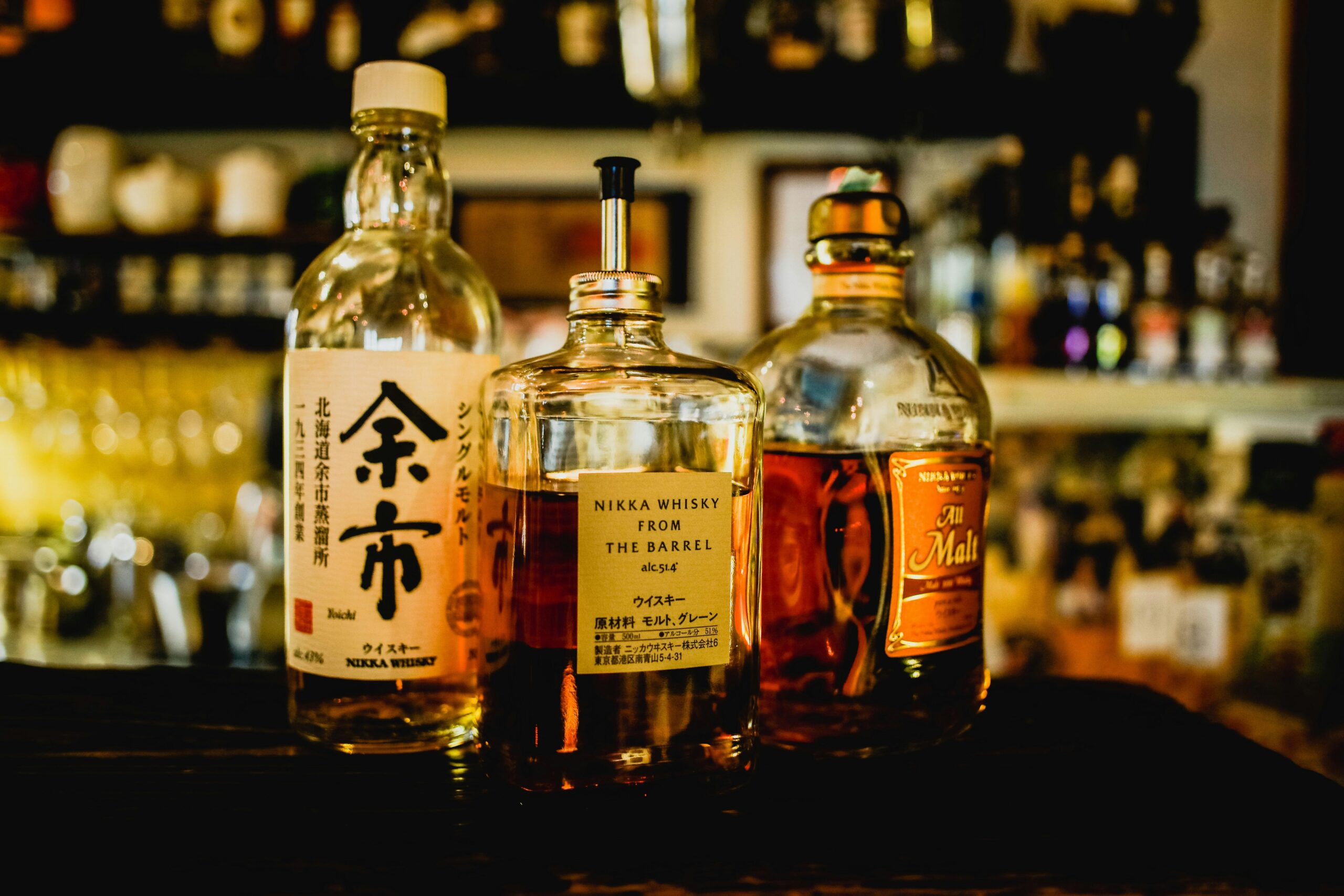 Selection of Japanese whisky bottles displayed in a dimly lit bar setting.